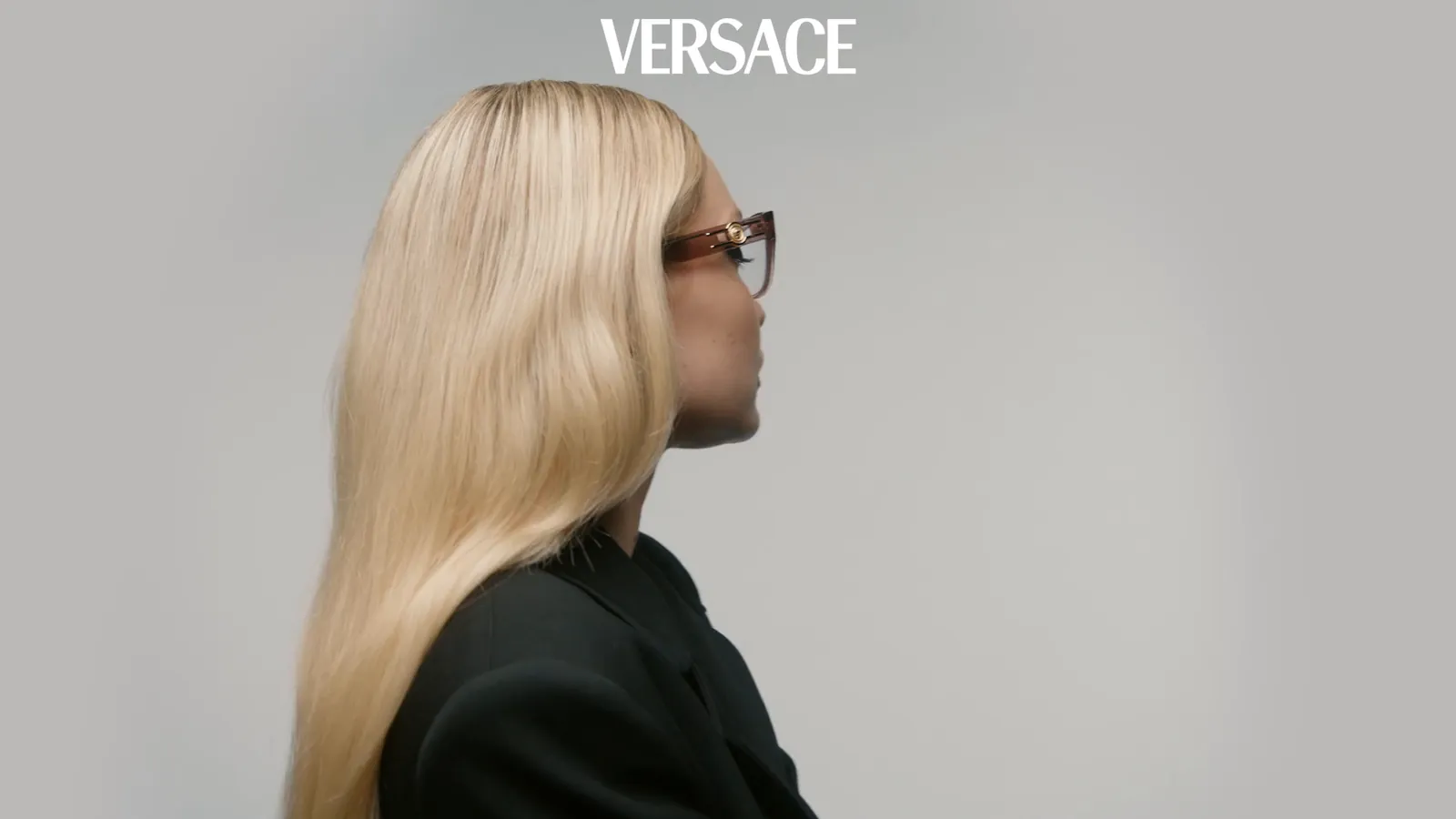 Campaña Versace: una modelo con monturas rosadas sobre un fondo gris